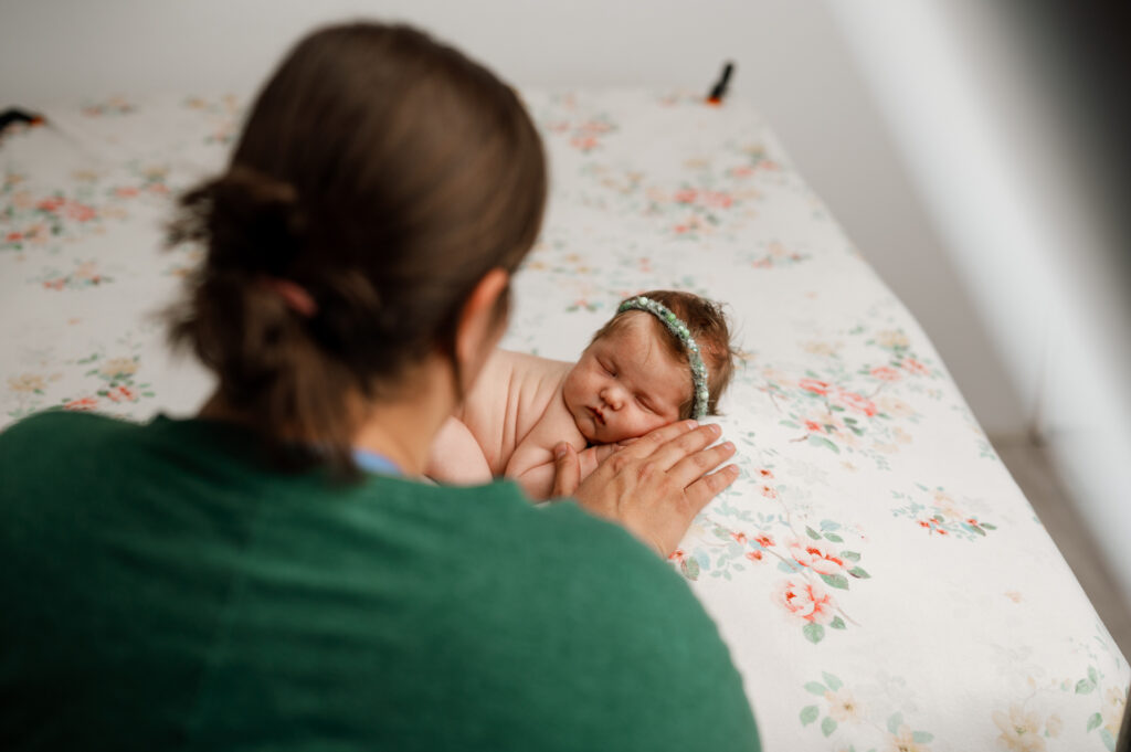 Posing baby on floral backdrop.